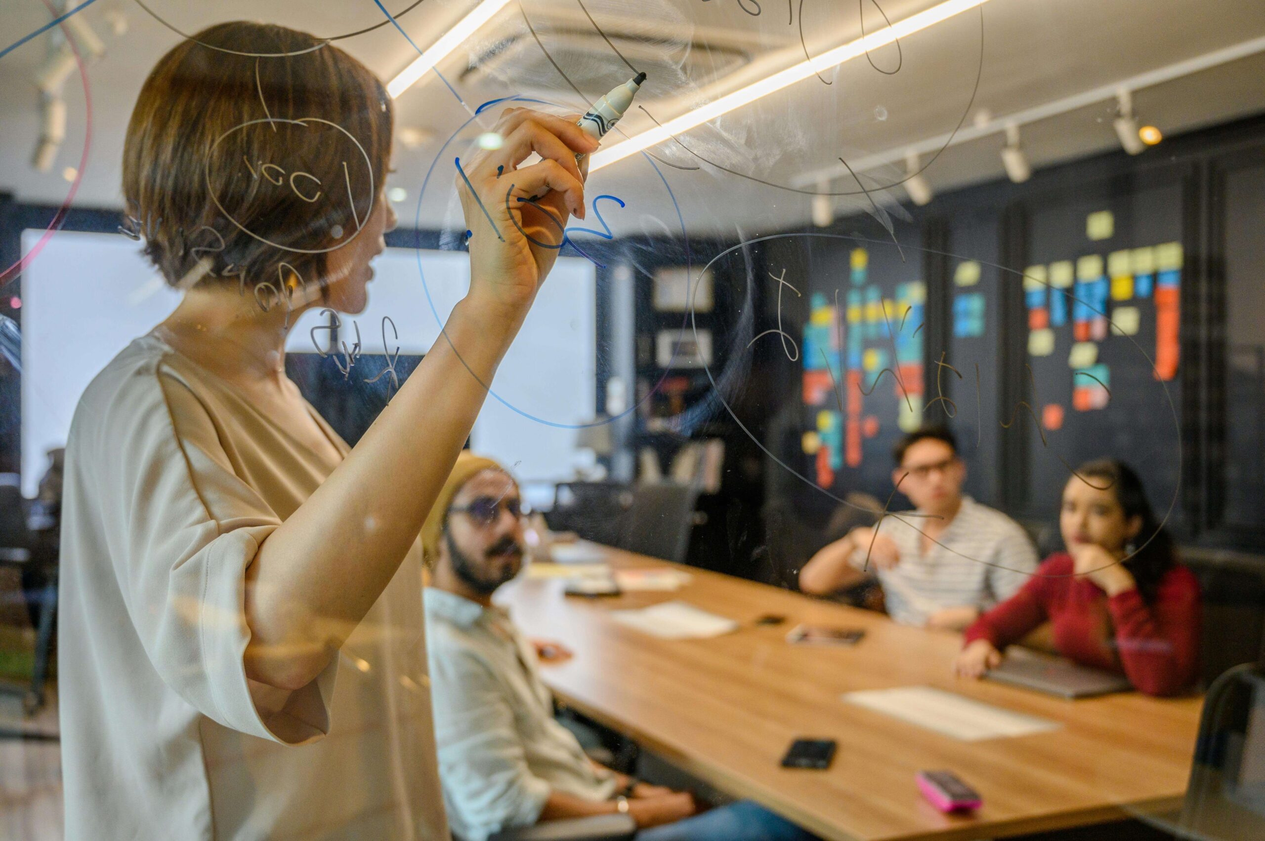 A Small Team Collaborates on Business Plan in Conference Room.